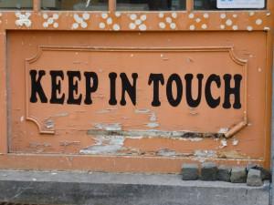 A sign of keep in touch written on wood